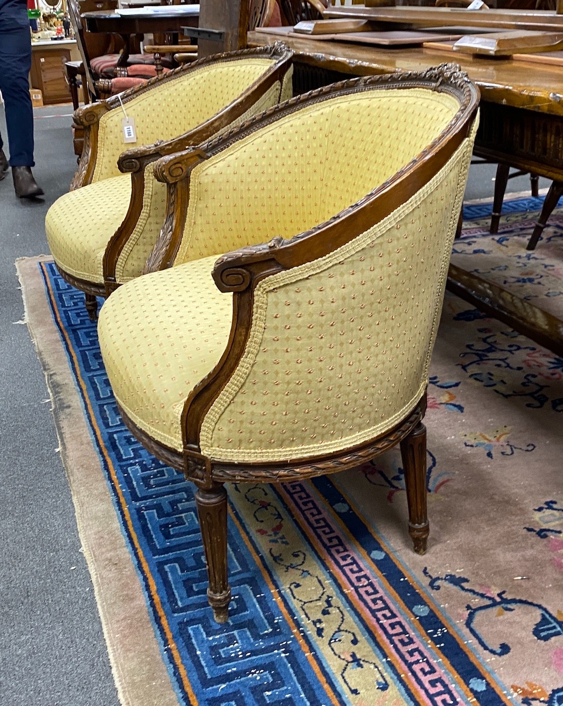A pair of Louis XVI style carved beech upholstered tub framed chairs, width 82cm, depth 50cm, height 77cm